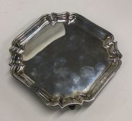 A square silver salver with decorative border. By