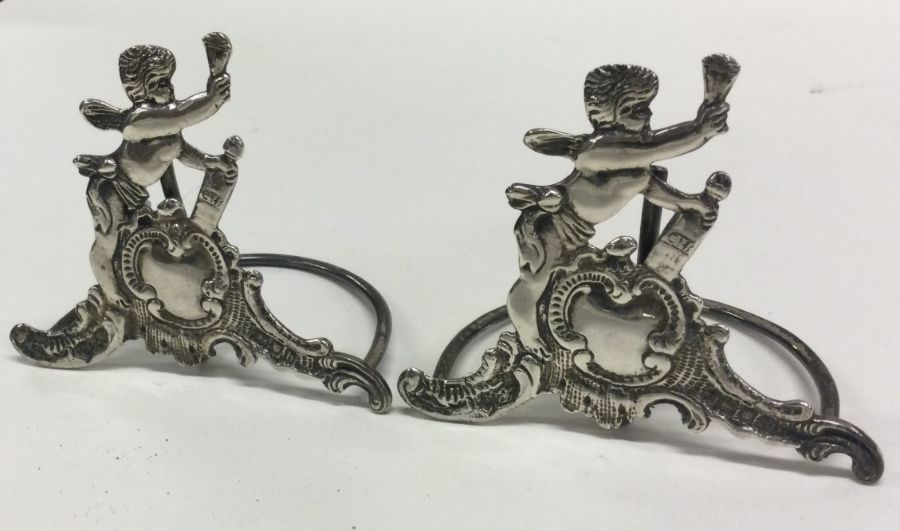 A pair of chased silver menu holders decorated wit