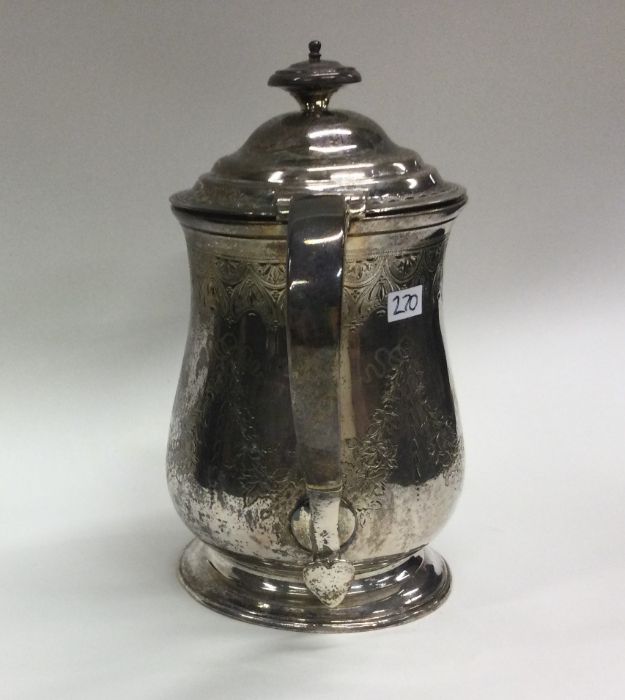 An Edwardian silver jug with engraved decoration.
