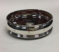 A good plain silver wine coaster with mahogany ins