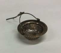 A silver tea strainer with chased border. Approx.