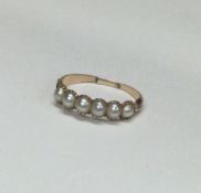 An Antique pearl seven stone ring in claw mount. A