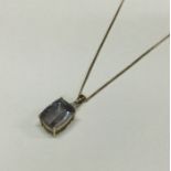 A large diamond mounted drop pendant on fine link