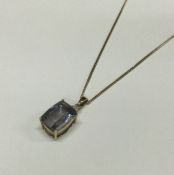 A large diamond mounted drop pendant on fine link