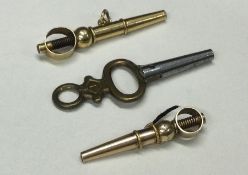 Two gold watch keys together with one plated examp