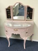 A pink painted triple mirror.