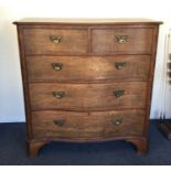 A large shaped front five drawer chest.