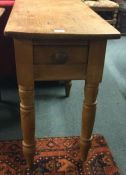 A small pine single drawer table.