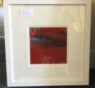 A framed small red abstract painting.