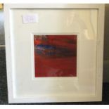 A framed small red abstract painting.