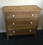 A striped pine chest of drawers.