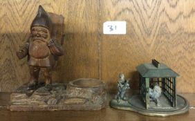A carved figure of a gnome together with one other