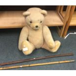 An old teddy bear together with two batons.