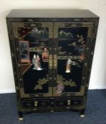 An Oriental lacquered cupboard.