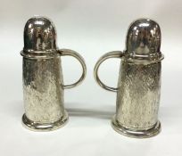 A rare pair of silver casters of hammered effect.