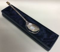 A large silver anointing spoon decorated with a pi