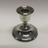 A heavy silver candlestick with embossed border. B
