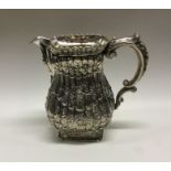 A large chased silver water jug with embossed flor