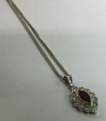 A ruby and diamond tear shaped pendant on fine lin