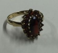 An oval garnet cluster ring in claw mount. Approx.