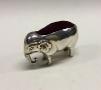 A silver pin cushion in the form of an elephant. B
