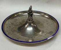 A large silver and enamel dish chased with a river