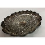 A heavy chased silver oval dish decorated with flo