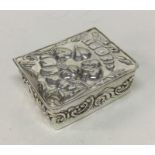 A chased hinged top English silver box with cherub