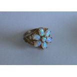 A good opal seven stone cluster ring set in 9 cara