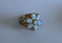 A good opal seven stone cluster ring set in 9 cara