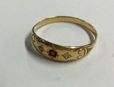 An 18 carat gold diamond and garnet gypsy set ring