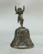 A chased silver table bell decorated with figures.
