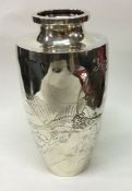 A decorative Japanese silver vase chased with eagl