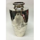 A decorative Japanese silver vase chased with eagl