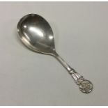 A silver caddy spoon with chased floral decoration