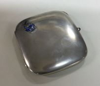 A silver and enamel cigarette case with blue stone