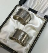 A cased pair of silver engraved napkin rings. Shef