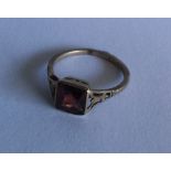 A 9 carat garnet single stone ring in pierced moun