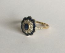 An attractive oval sapphire and diamond cluster ri