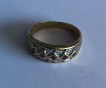 A ruby and diamond mounted three row ring in 9 car