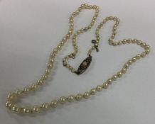 A tapering string of graduated pearls on silver pa