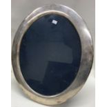 A large oval silver picture frame. London. By Mapp
