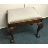 A mahogany framed stool on ball and claw feet. Est