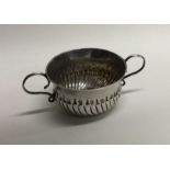 A rare miniature Queen Anne silver porringer with fluted body.