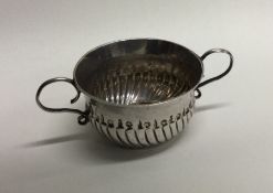 A rare miniature Queen Anne silver porringer with fluted body.