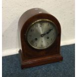 A mahogany inlaid clock with silvered dial. Est. £