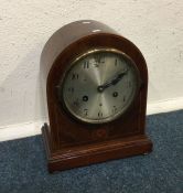 A mahogany inlaid clock with silvered dial. Est. £
