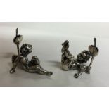 A pair of silver menu holders in the form of cheru