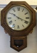 An Edwardian oak wall clock with white enamelled d