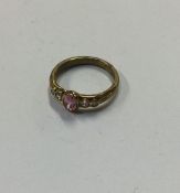 A small diamond mounted and pink stone ring in tex